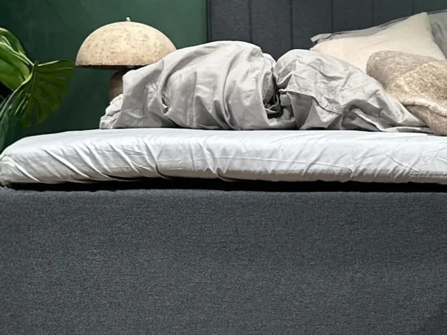 Κοντινή λήψη του σεντονιού FamBed τεντωμένου πάνω από το ανώστρωμα ενός οικογενειακού κρεβατιού